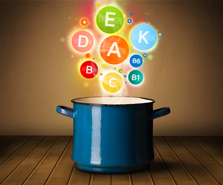 Colorful vitamins coming out from cooking pot, healthy food conceptの写真素材