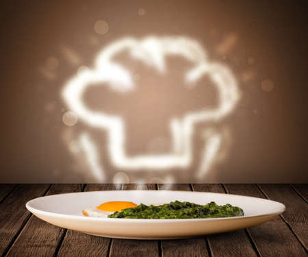 Delicious food plate with chef cook hat on wood deckの写真素材