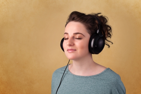 Pretty young woman with headphones listening to music with empty spaceの写真素材