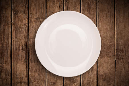 Colorful empty shiny plate on grungy background table の写真素材