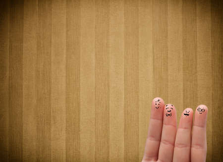 Happy finger smileys faces on hand with vintage stripe wallpaper background