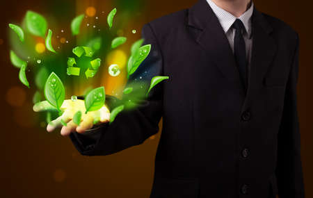 Young business man in suit presenting eco green leaf recycle energy conceptの写真素材
