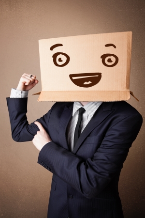 Businessman standing and gesturing with a cardboard box on his head with smiley faceの写真素材