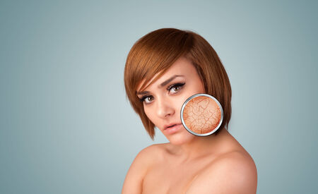Healthy beautiful young girl with magnifying glass of skin damageの写真素材