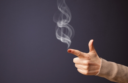 Gun shaped woman hand with smokeの写真素材