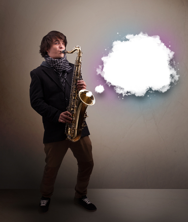 Handsome young man playing on saxophone with copy space in white cloudの写真素材