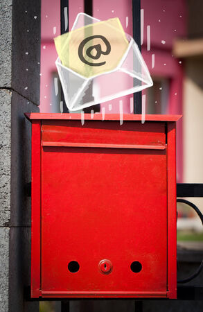 White envelope with email sign dropping into mailboxの写真素材