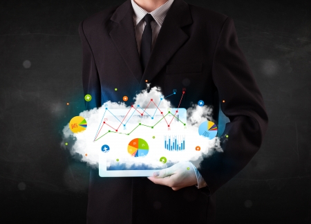Person holding a white touchpad with cloud technology and chartsの写真素材