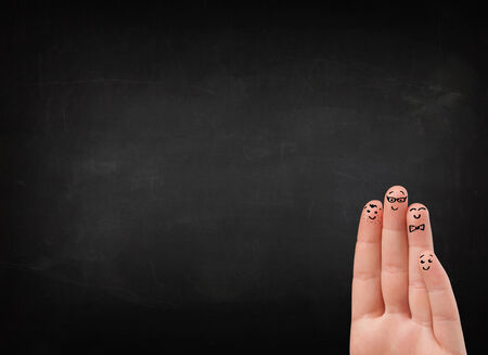 Happy cheerful smiley fingers looking at empty black chalboard