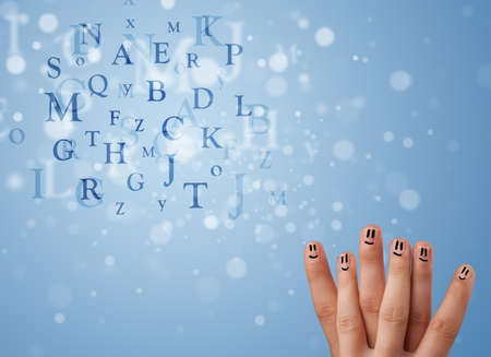 Happy cheerful smiley fingers looking at mixture of bokeh lettersの写真素材