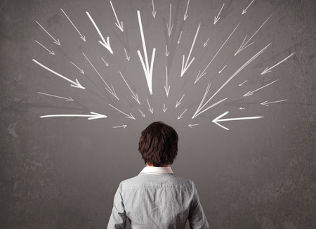 Business man with hand drawn arrows pointing at his head conceptの写真素材