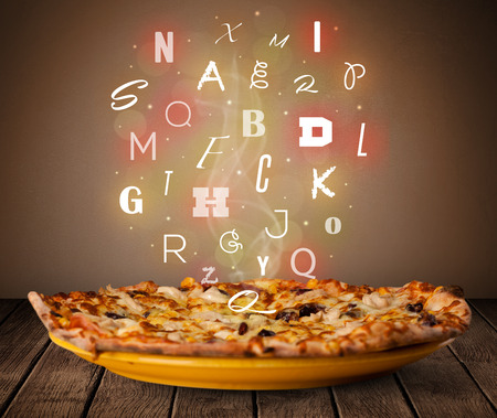 Fresh italian pizza with colorful letters on wood deckの写真素材
