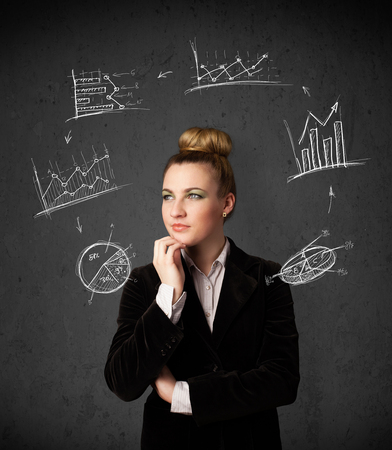 Thoughtful young woman with drawn charts circulating around her headの写真素材