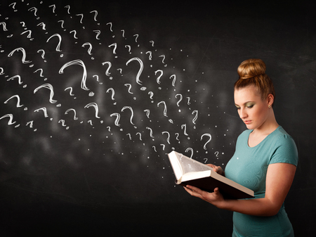 Confused woman reading a book with question marks coming out from itの写真素材
