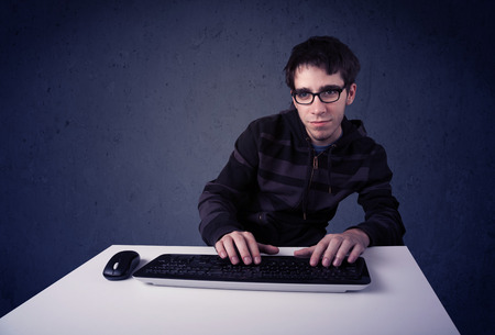 Hacker working with keyboard and mouse on blue background