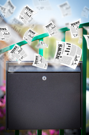 Post box with daily newspapers flying outの写真素材