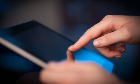 Hand touching tablet pc with copy spaceの写真素材