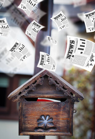 Post box with daily newspapers flying outの写真素材