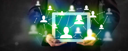 Young person presenting tablet with green social media icons and symbols