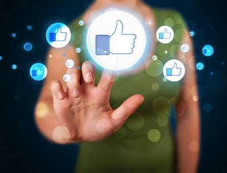 Young person pressing thumbs up button on modern social network system