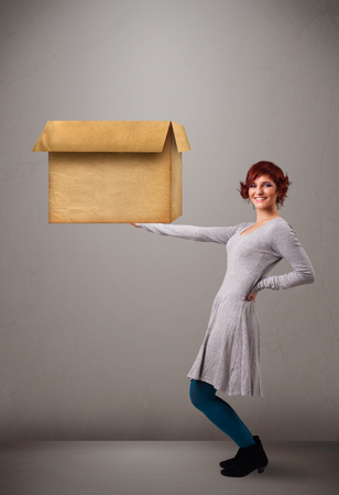 Beautiful young woman holding an empty cardboard boxの写真素材