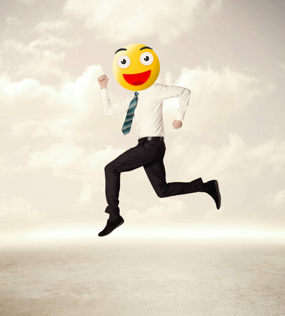 Funny businessman wears yellow smiley faceの写真素材