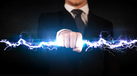 Business man holding electricity light bolt in his hands conceptの写真素材