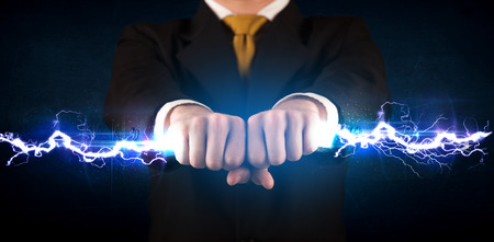 Business man holding electricity light bolt in his hands conceptの写真素材