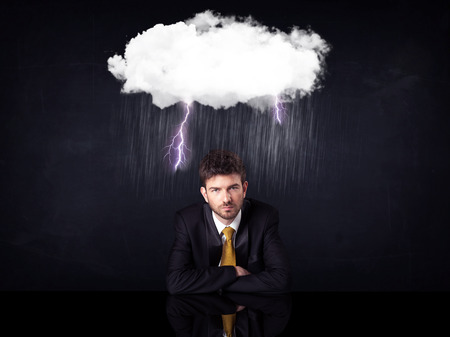 Depressed businessman sitting under a lightning rainy cloudのeditorial素材