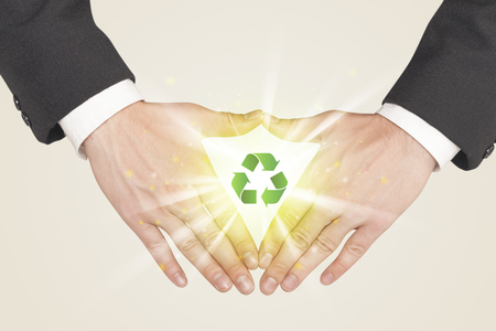 Hands creating a form with green recycling sign in the centerの写真素材