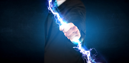 Business man holding electricity light bolt in his hands conceptの写真素材