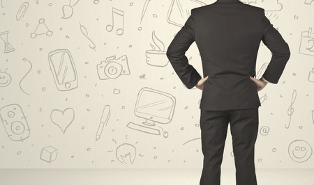 Businessman from the back in front of an social media icon wallの写真素材