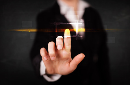 Tech woman touching button with orange light beams conceptの写真素材