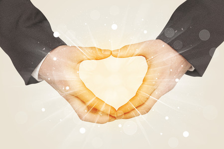 Hands creating a form with yellow shines in the centerの写真素材