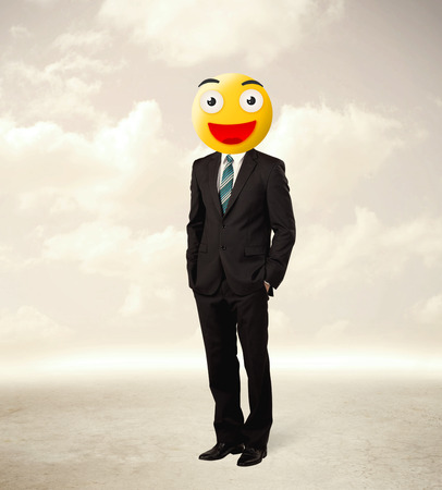 Funny businessman wears yellow smiley faceの写真素材