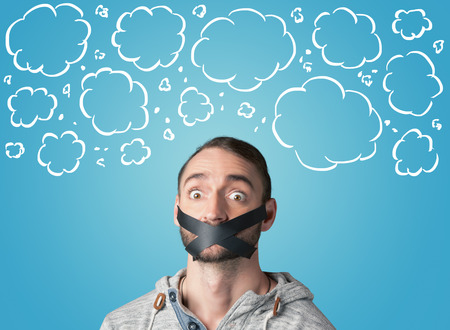 Funny person with taped mouth and hand drawn clouds around headの写真素材