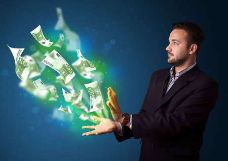 Young businessman holding glowing paper moneys in his hand