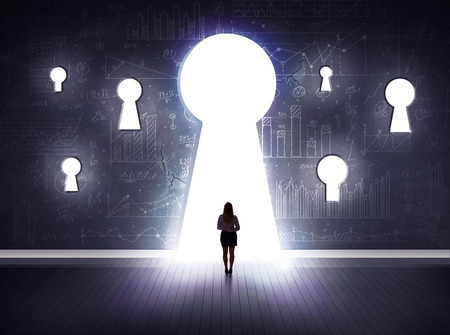 Successful businessman looking through keyholeの写真素材