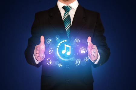 Businessman holding digital multimedia iconsの写真素材