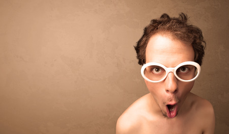 Portrait of a young pretty man with sunglasses and copyspace on brown backgroundの写真素材