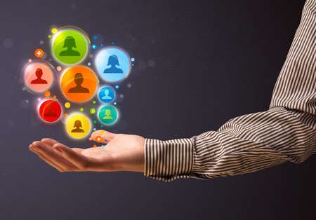 Businessman holding colorful social network icons in his handの写真素材
