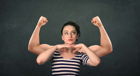 Pretty young woman with strong and muscled arms conceptの写真素材
