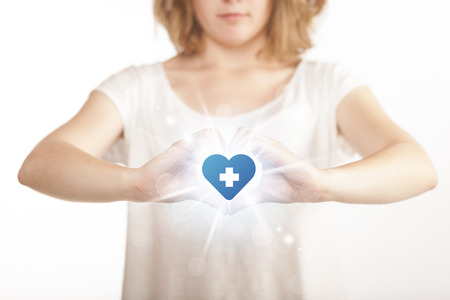 Hands creating a form with shining heart blue cross in the centerの写真素材