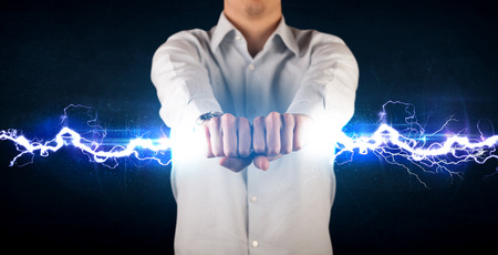 Business man holding electricity light bolt in his hands conceptの写真素材