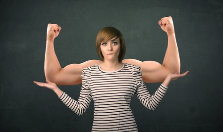 Pretty young woman with strong and muscled arms conceptの写真素材
