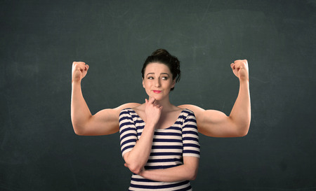 Pretty young woman with strong and muscled arms conceptの写真素材