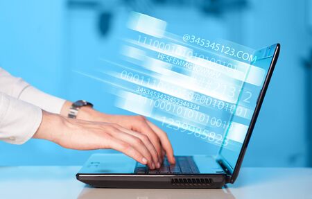 Close up of man typing on laptop computer with glowing technology effect