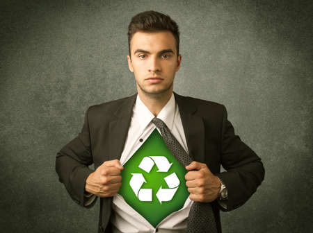 Enviromentalist business man tearing off shirt with recycle sign on his chest concept on backroundの写真素材