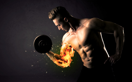 Bodybuilder athlete lifting weight with fire explode arm concept on backgroundの写真素材
