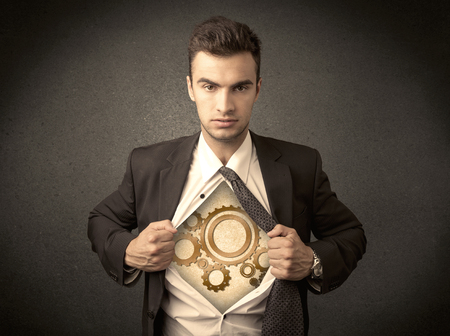 Businessman tearing shirt off and machine cog wheel shows on his chest concept on backgroundの写真素材